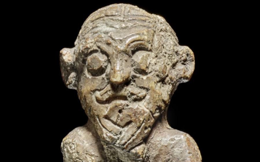 The small walrus ivory figurine discovered in Denmark's National Museum, showing intricate Viking hairstyling 