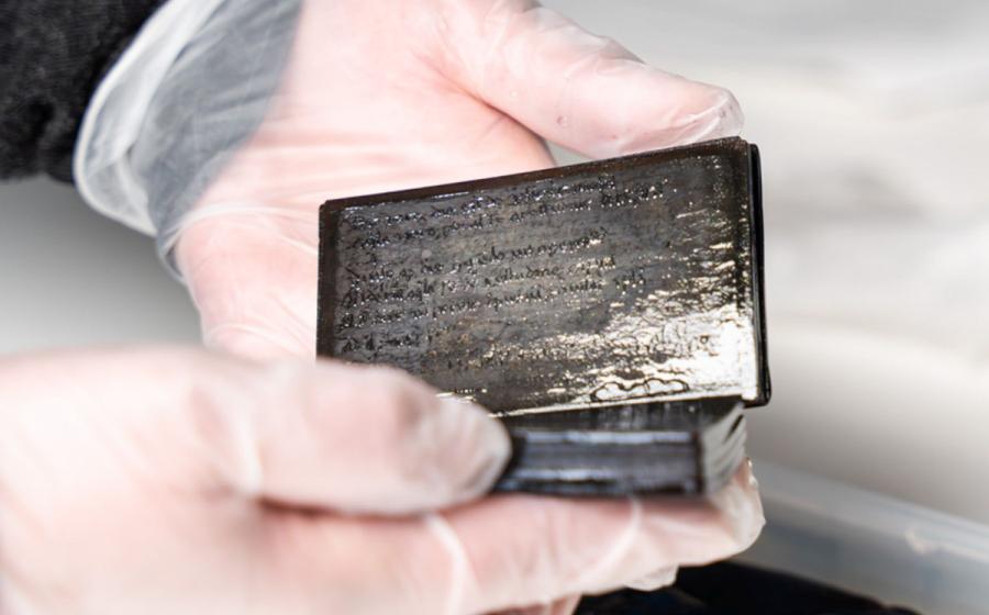 Researcher holding the 13th-14th century medieval wax notebook.