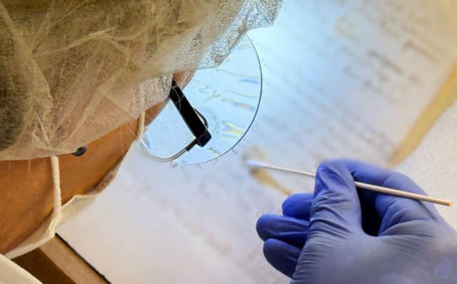 Artist Karina Åberg swabs a 14th century da Vinci family letter from the State Archive in Prato