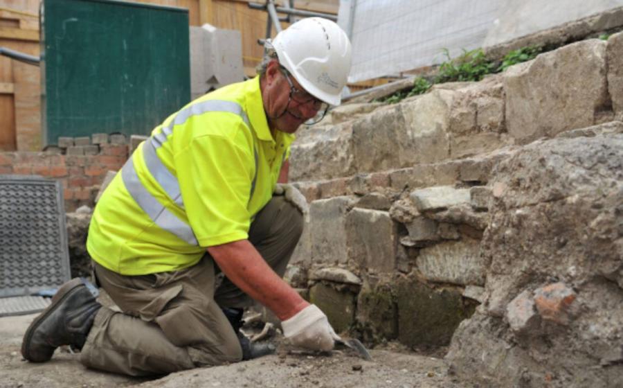 Cotswold Archaeology worker excavating in the area where the medieval graves and other artifacts were discovered. 