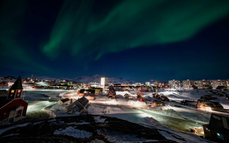 Nuuk, Greenland skyline with the aurora borealis shining overhead.