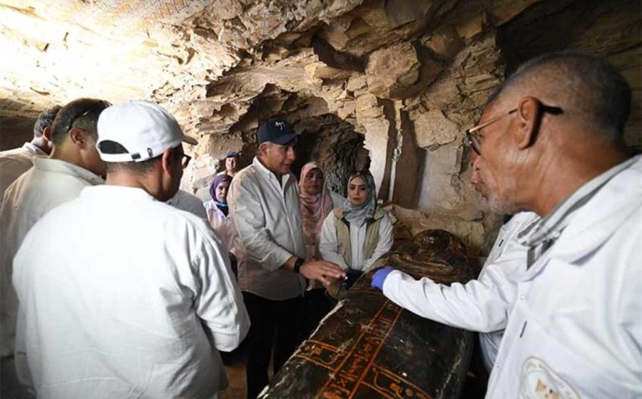 Egyptian officials and archaeologists inspect one of the newly uncovered coffins at Dra Abu El-Naga,
