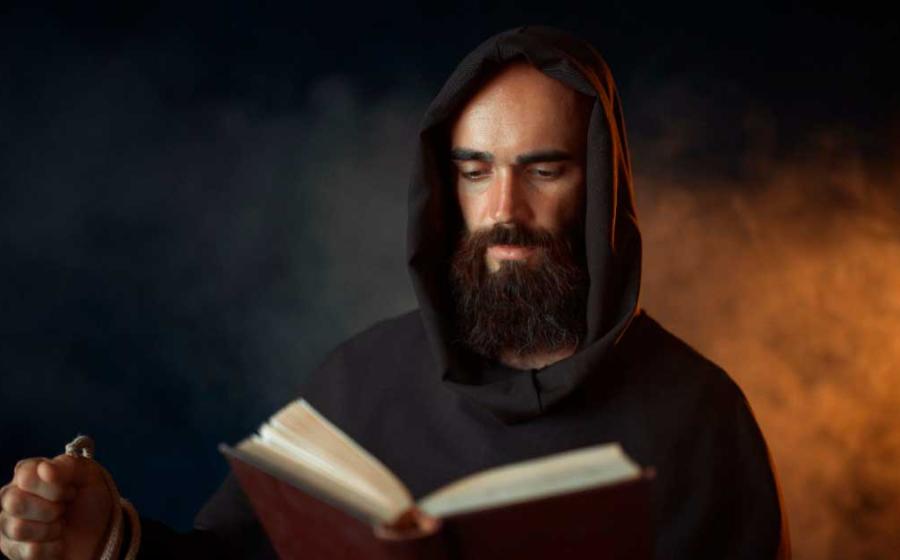 Medieval monk praying with a Bible and a rosary.	Source: Nomad_Soul / Adobe Stock