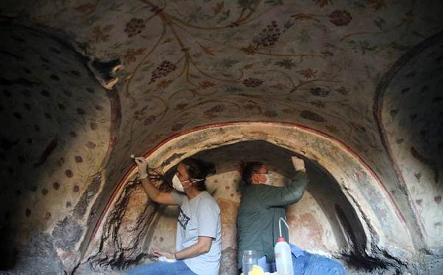 Archaeologists clean the motifs on the walls of a tomb found in the ancient city of Blaundus, Turkey.	Source: Anadolu Agency
