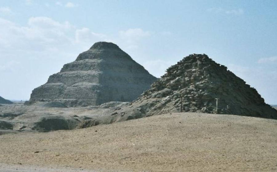 View of Saqqara necropolis, including Djoser's step pyramid (center), the Pyramid of Unas (left) and the Pyramid of Userkaf (right).