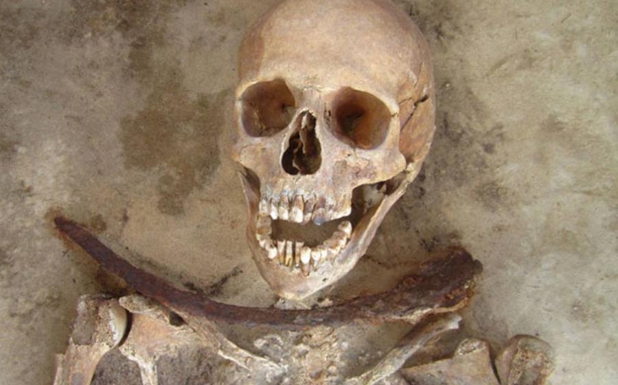 30-39 year old female’s remains with iron sickle placed across neck