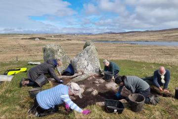 Archaeologists and community volunteers excavate around the surviving upright stones of the Leaval chambered cairn