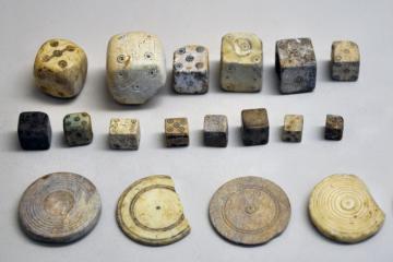 A collection of Roman bone dice and gaming counters from the Gallo-Roman Museum of Saint-Romain-en-Gal, France