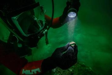 The Lighthouse of Alexandria ring at the time it was found held by underwater archaeologist.