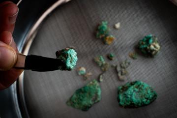 Malachite fragments, a mineral rich in copper, recovered during the excavation works at Cova 338.