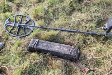 A lead ingot near the find site, with the metal detector that found it.