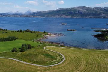 Herlaugshaugen (in the center foreground) from the west, looking towards the strait and the mainland in the background