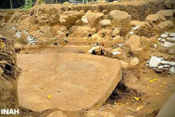 A large carved monolithic sculpture slab in the excavation trench, Coatepec, Veracruz.