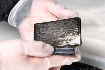 Researcher holding the 13th-14th century medieval wax notebook.