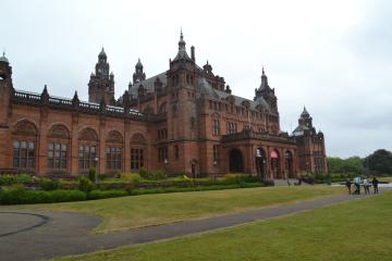 Red sandstone exterior of Kelvingrove Art Gallery and Museum behind a lawn
