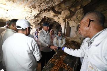 Egyptian officials and archaeologists inspect one of the newly uncovered coffins at Dra Abu El-Naga,