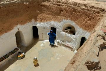 A whitewashed sunken courtyard in the Matmata area of Tunisia, with doorways cut into the surrounding walls
