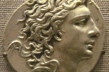A coin showing the profile of a young king with long, windswept hair
