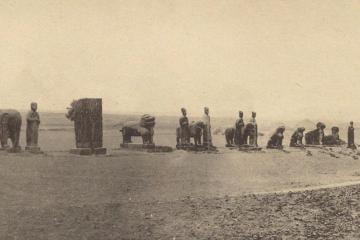 A long line of stone animals and figures standing on open ground along the spirit way of Yongxi Mausoleum, photographed in 1918