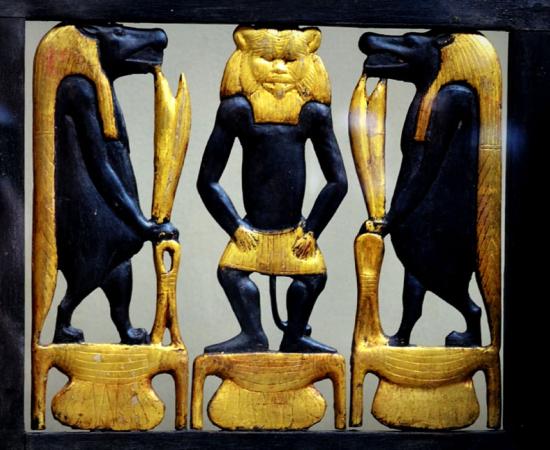 Detail from the richly decorated wooden chair or ‘throne’ of Sitamun, daughter and later wife of Amenhotep III, which was found in KV46. The image shows richly gilded images of Bes and two Tawaret figures; design by Anand Balaji (Photo credit: Heidi Kontkanen - Egyptian Museum, Cairo); Deriv.