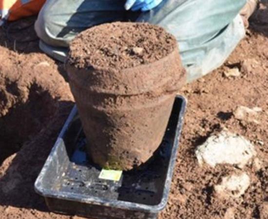 ANU Archaeologist Dr Catherine Frieman & co-director James Lewis with funerary pot in situ.