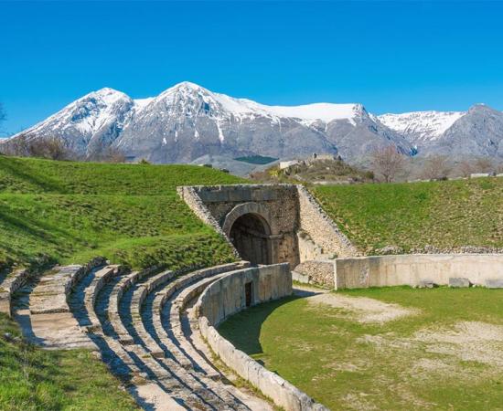 Alba Fucens, Roman archaeological site with amphitheater. Monte Velino mountain with snow, Abruzzo region, central Italy   Source: ValerioMei / Adobe Stock