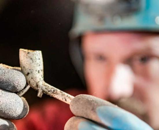 Derbyshire Caving Club member examines a pipe found in the Alderley Edge Cobalt mine. Source: National Trust