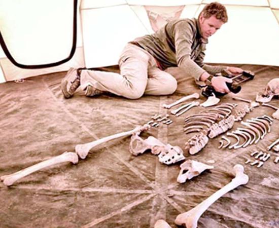 Researcher and filmmaker Jake Norton photographs a 1,200-year-old skeleton from Samdzong, Nepal. 