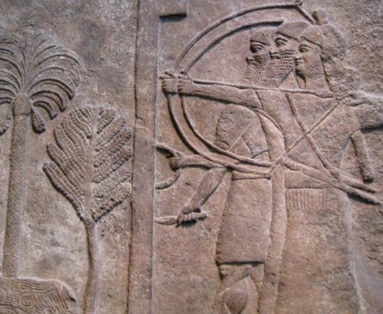 Relief, circa 728 B.C., depicting an Assyrian warrior holding a large shield to protect two archers taking aim, from the Central Palace in Nimrud and now in the British Museum, London. 