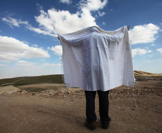 A Jewish prayer shawl adorned with ritual tassels that contain tekhelet-dyed threads.