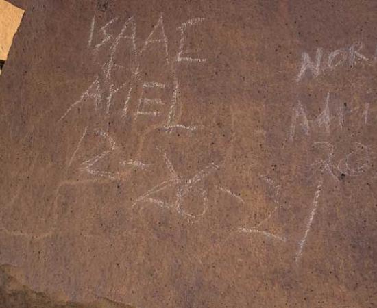 The surface of a petroglyph stone in the Indian Head area of Grand Bend National Park, where four vandals wrote their names and the date on December 26, 2021.					Source: National Parks Service