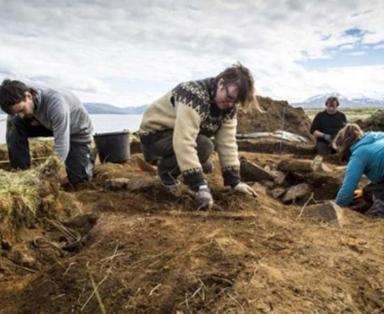 Archaeologists dig at the site of the first ship burial, where the human and dog bones, the ship and sword were found. You can see how close the waters of the fjord are in the background.