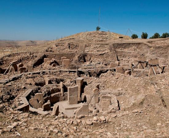 Göbekli Tepe's excavated stone enclosures and surrounding hill in southeastern Turkey.   