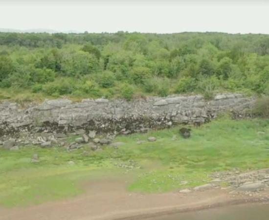 Field archaeologist Michael Gibbons, left, discovered the outlines of this gigantic Bronze Age fortress, partially visible in the background of this image, which may be nearly 3,200 years old, while carrying out routine field work in a nature preserve in County Galway, Ireland.	Source: YouTube screenshot / RTE News