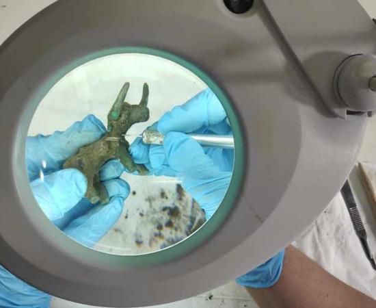 Conservators clean up the bronze bull idol uncovered in Olympia.	Source: Greek Ministry of Culture and Sports