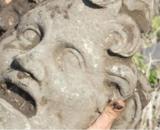 A University of Haifa researcher holds the unique bronze mask of the god Pan 