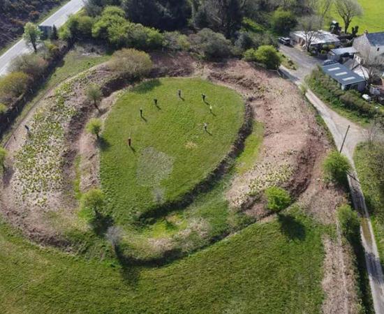 An aerial view of Castilly Henge, a classic horseshoe henge that had long been hidden in dense vegetation in a lonely landscape.		Source: Cornwall Archaeological Unit / Historic England