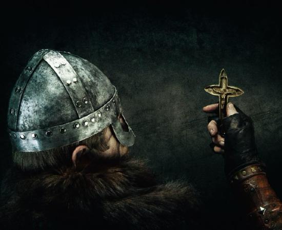 Viking holding Christian cross. Credit: Warpedgalerie / Adobe Stock