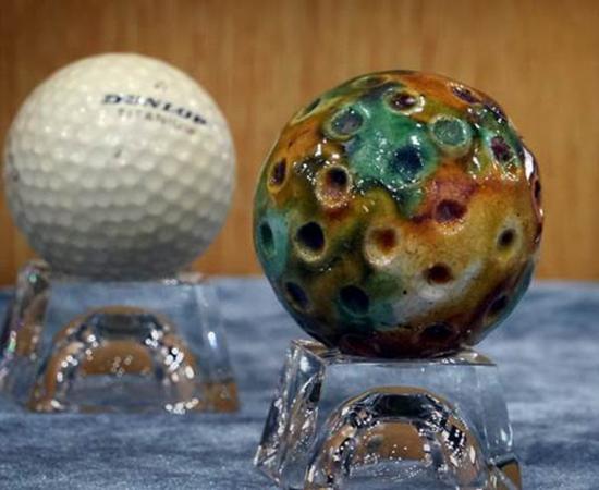 A ceramic Chuiwan golf ball (R) and a modern golf ball (L) displayed in an art gallery at Pingdingshan University, Henan Province, China.	Source: Li An / Xinhua