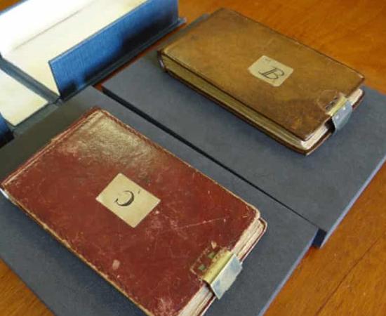 Darwin’s notebooks, stolen in 2000-2001, on top of their original box, with the box from “X” at the top. 	Source: Cambridge University Library