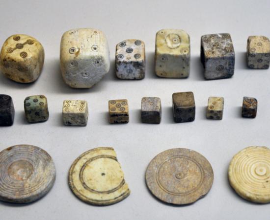 A collection of Roman bone dice and gaming counters from the Gallo-Roman Museum of Saint-Romain-en-Gal, France