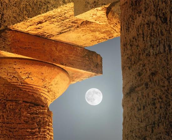 The moon among the columns of the Doric Temple at Segesta, Sicily. 	Source: ildiora / Adobe Stock