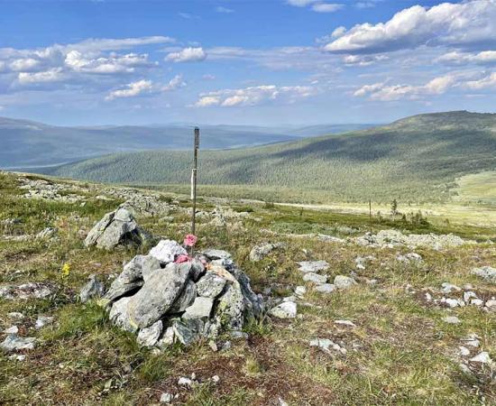 This stone cairn and flag marker sits on the very location of the Dyatlov Pass incident tent spot where in 1959 nine experienced hikers died under mysterious circumstances.         Source: irinabal18 / Adobe Stock