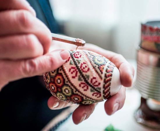 Lady making traditional decorated eggs in the Bukovina Region of Romania. Source: Matthew / Adobe Stock. 
