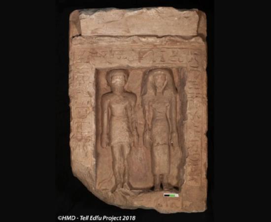 Limestone stela showing a man and woman standing next to each other, which shows signs of having been defaced. 