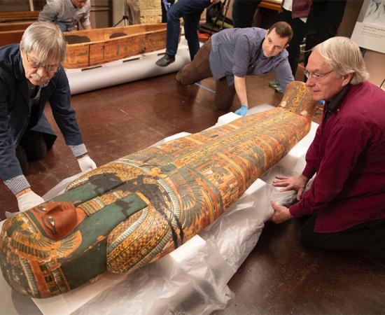 Dennis Piechota (from left), Adam Middleton, and Joe Green work on the ancient Egyptian coffin of Ankh-Khonsu with a team at the Semitic Museum. Source: Kris Snibbe / Harvard Gazette.