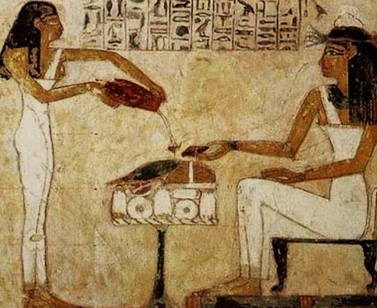 Painting of an ancient Egyptian woman being served beer.