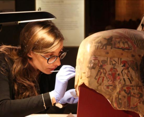 Researchers extracting samples of Egyptian paint from artifact.