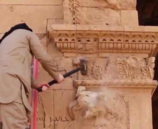 An Islamic State militant destroying artifacts in Iraq’s World Heritage city of Hatra 