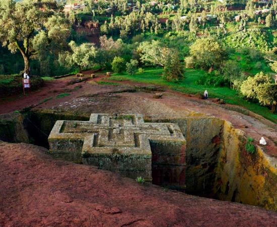 Top down view of an Ethiopian Church Forest in the early morning.  Several white-robed worshipers around the church.  Source: Gregory/Adobe Stock